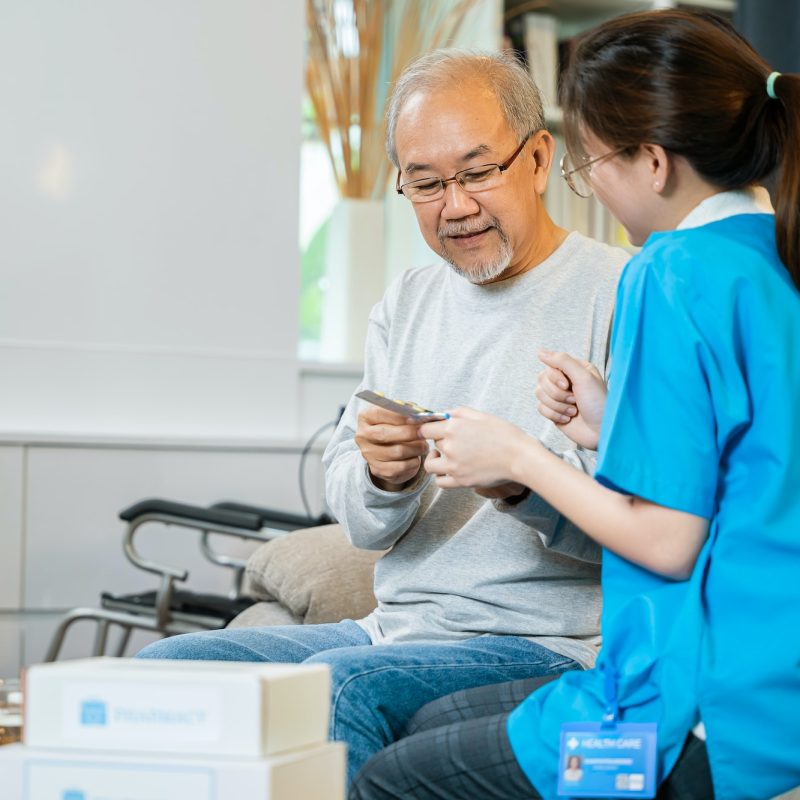 woman-nurse-caregiver-showing-prescription-drug-to-senior-man-at-nursing-home.jpg